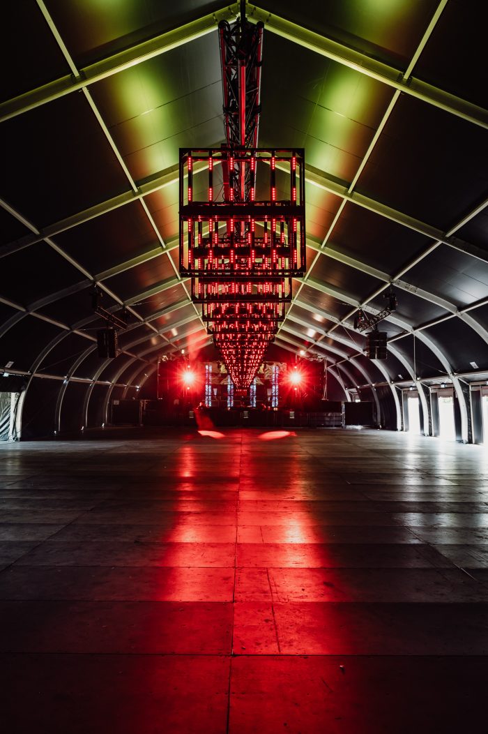 Lege, verduisterende TFS tent ingericht met rode verlichting voor een evenement.