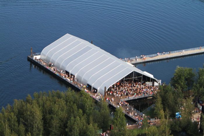 TFS tent op een pier bij een meer en bos voor een evenement.